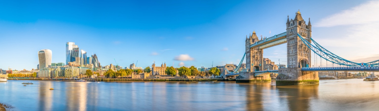 Confidence coach in London, the City skyline and Tower Bridge over the Thames at sunrise