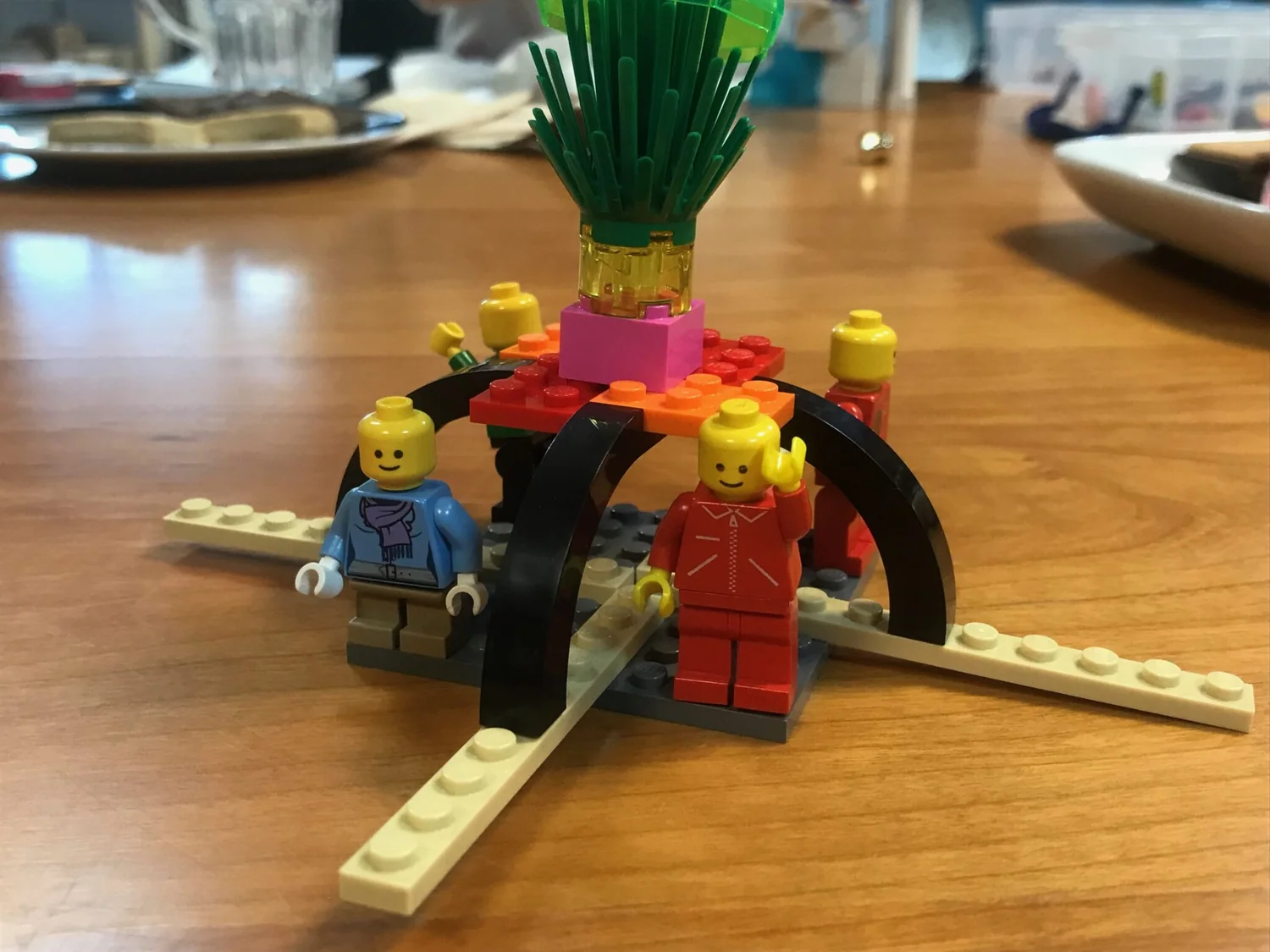 A team building LEGO® models around a table